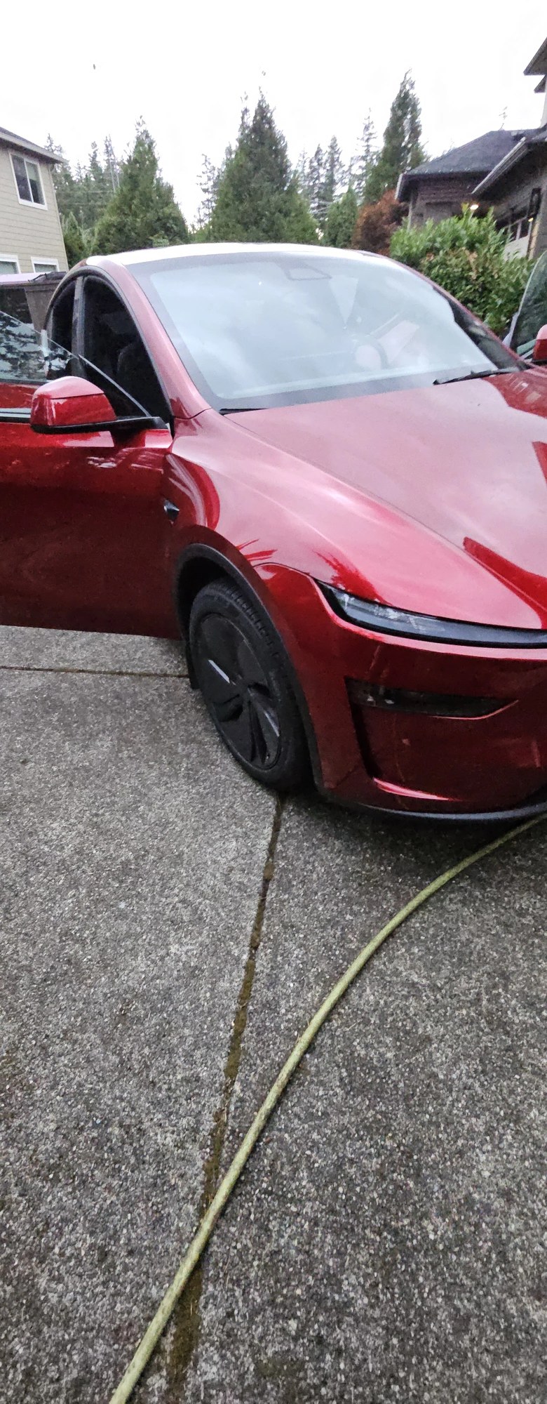 Rear quarter detail on red Tesla Model Y, wheels cleaned